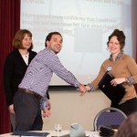 Presenter shaking hands with woman during certificate presentation